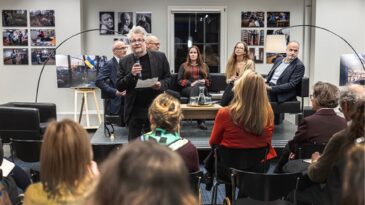 Publik och presentatör på ett panelsamtal och vernissage i Bern.